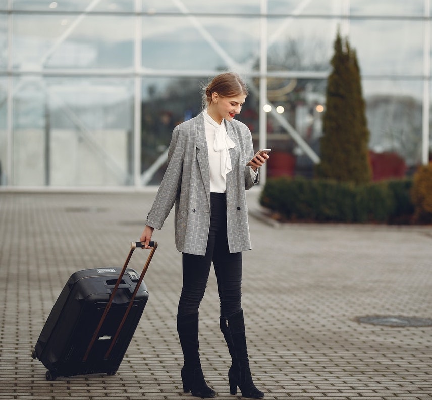 integration-subsistence-allowance Woman looking at the phone with a suitcase